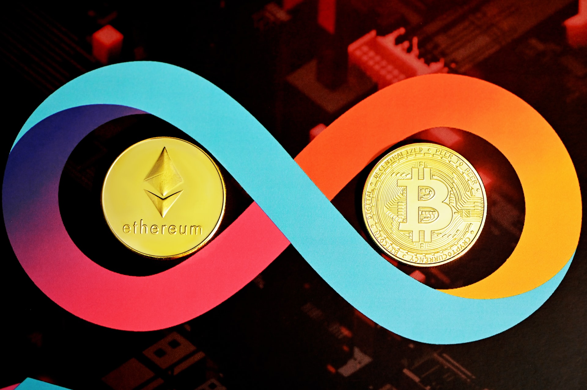 Två mynt, ett med symbolen för bitcoin och ett för Ethereum, i ett färgglatt evighetstecken. 